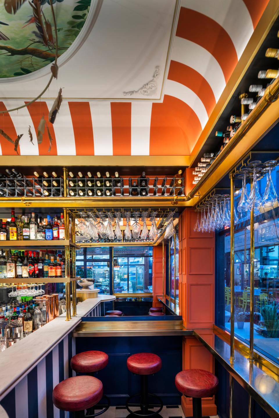 Stylish 3.5m2 bar interior in Brixton, featuring vibrant colors, decorative ceiling, and an extensive drink selection.