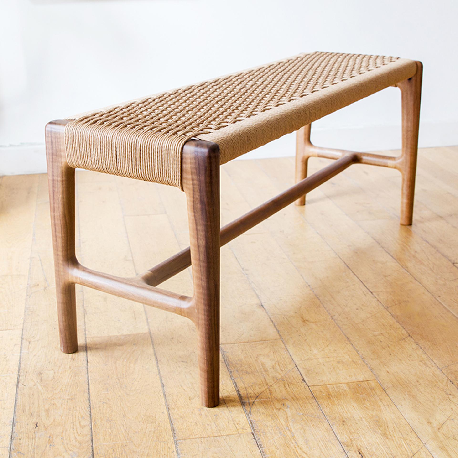 Handcrafted wooden bench with woven seat, showcasing contemporary design at the Great Northern Contemporary Craft Fair in Manchester.