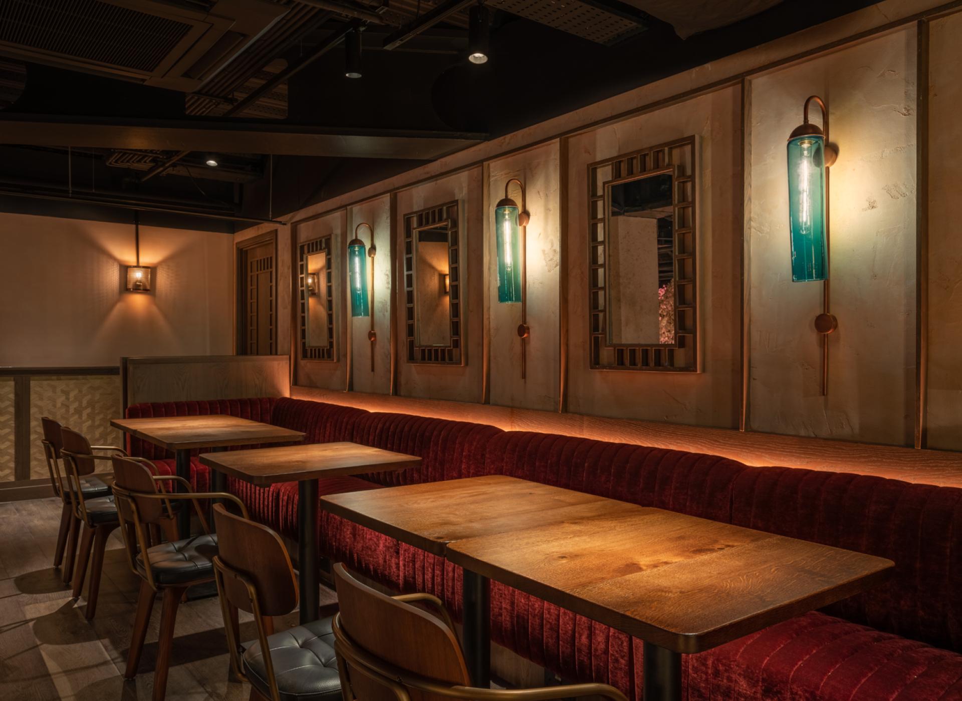 Interior design of Chef Andrew Wong's restaurant, featuring plush seating, wooden tables, and stylish lighting at Bloomberg Arcade.