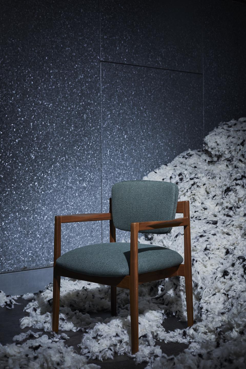 Stylish green tweed chair by Camira, showcasing innovative textile design with pure wool and flax materials.