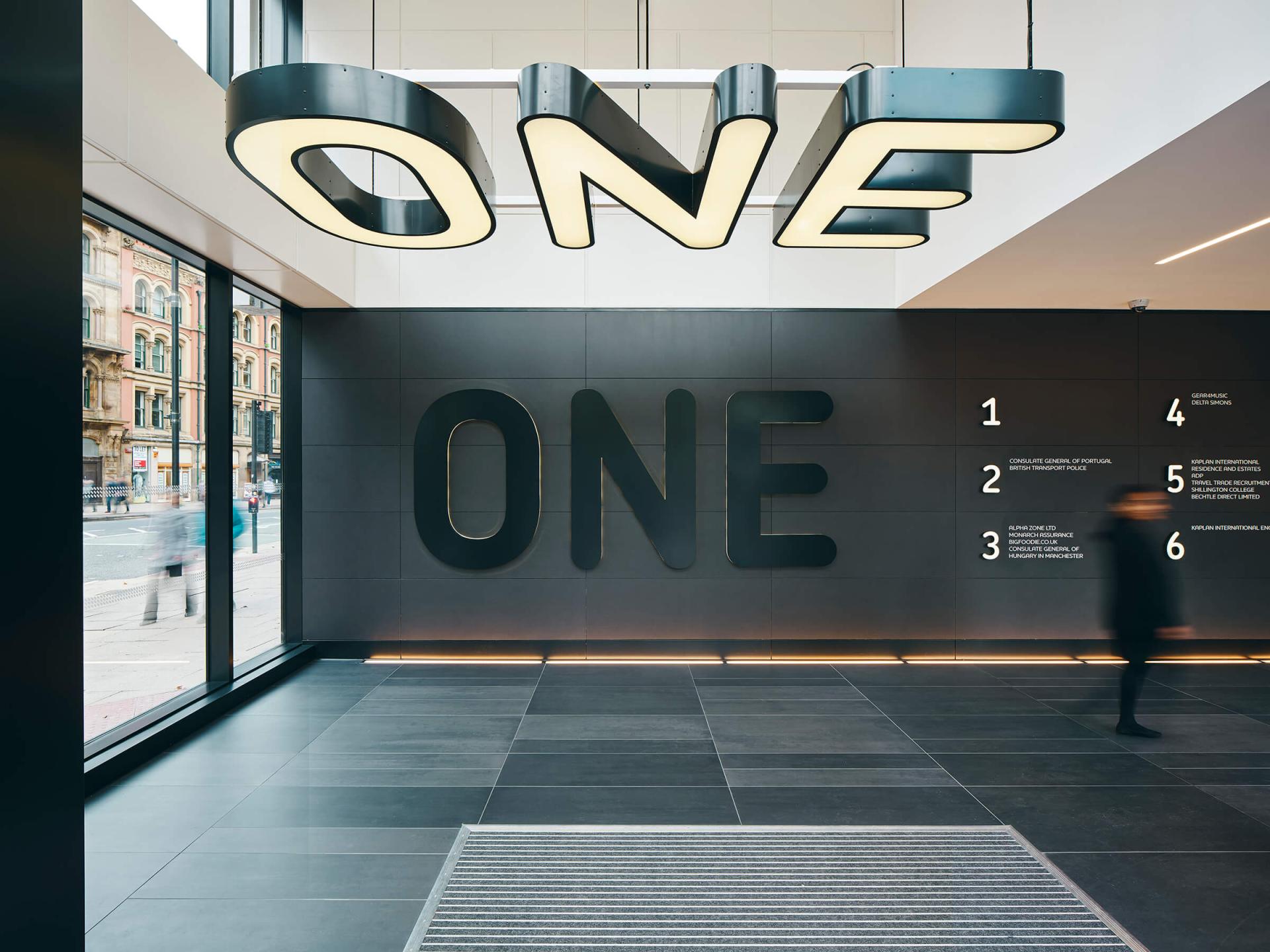 Modern interior design featuring bold "ONE" signage, showcasing innovative commercial space concepts by Jasper Sanders + Partners.