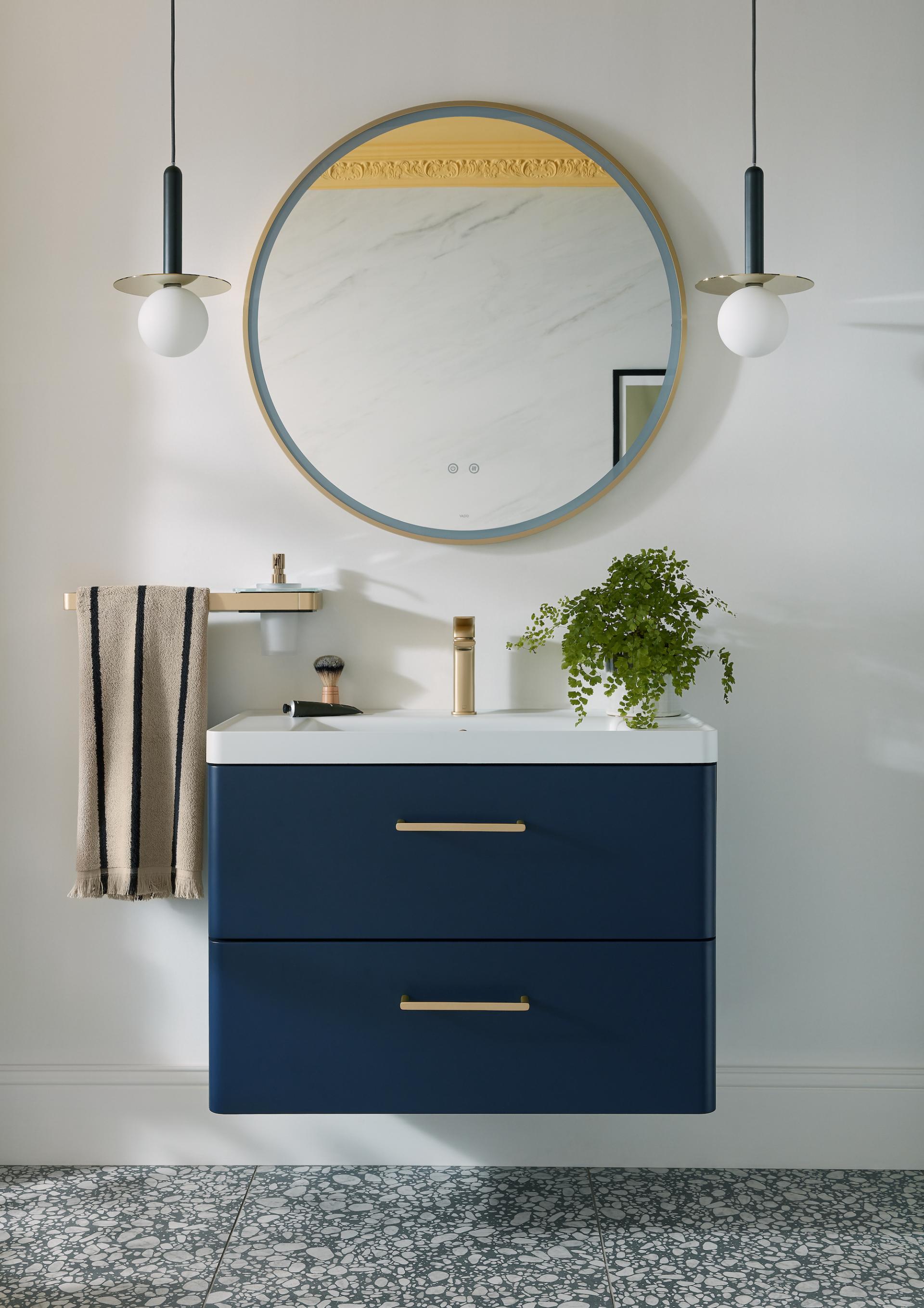 Modern bathroom setup featuring VADO's sleek navy drawer unit, elegant round mirror, and stylish accessories.