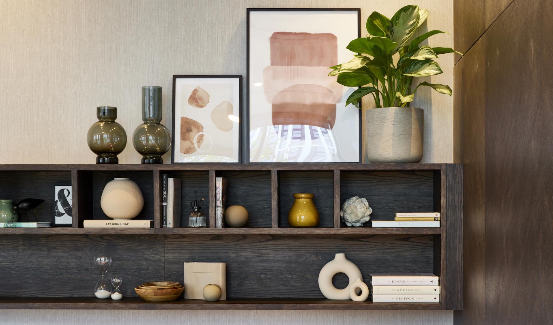 Modern interior design featuring decorative shelves, vases, books, and plants in the amenity space at Novella.