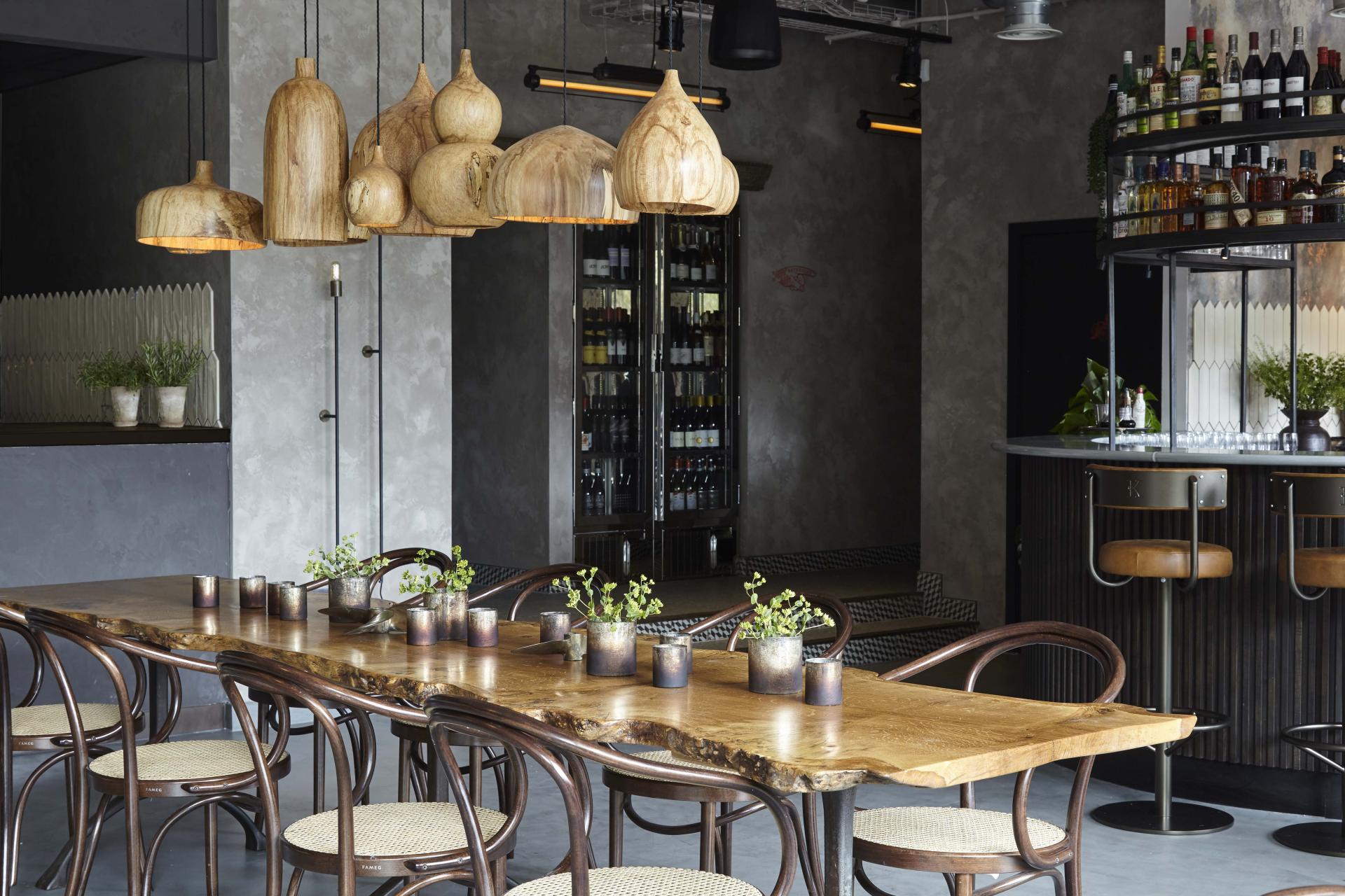 Stylish interior of Kricket restaurant with wooden decor, elegant lighting, and a welcoming dining atmosphere at Television Centre.