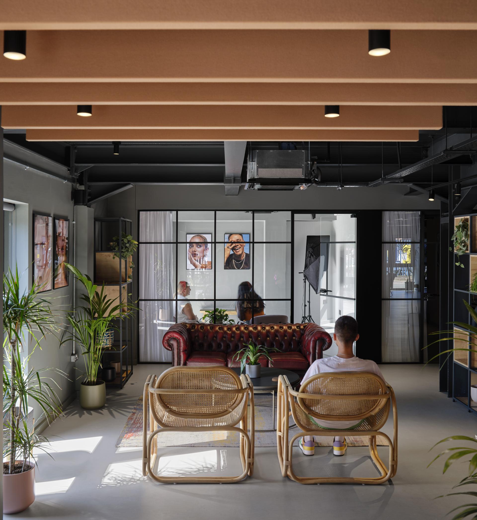 Stylish interior of J’adore Models' new headquarters featuring a cozy lounge area and natural greenery.