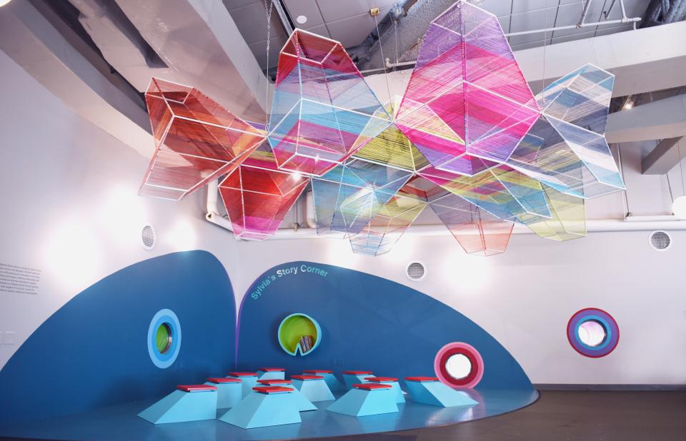 ColorLab's vibrant art space features colorful hanging sculptures above geometric seating for children in Brooklyn.