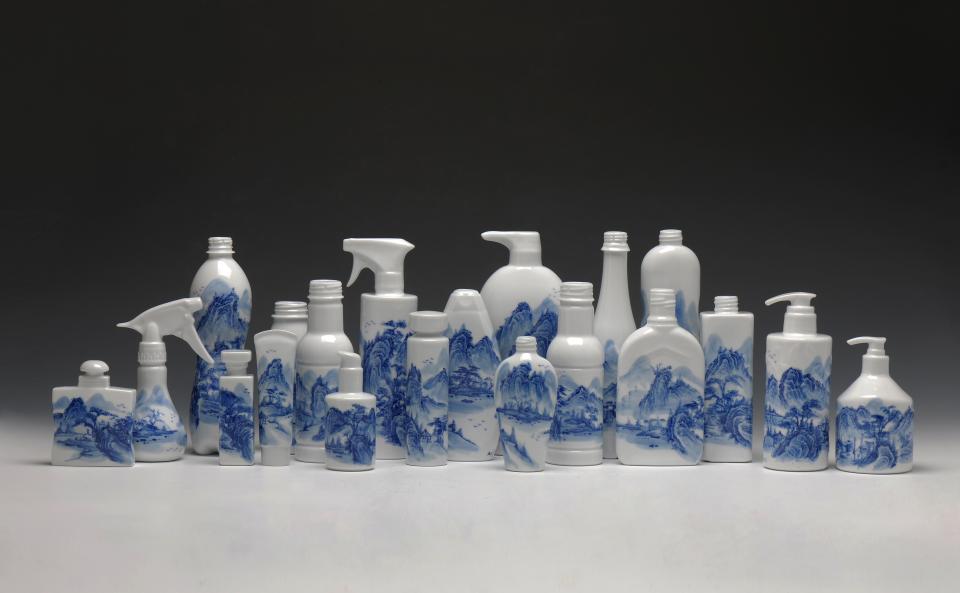 Ceramic bottles with blue and white landscape designs displayed artistically, highlighting modern craft and design at the Collect art fair.
