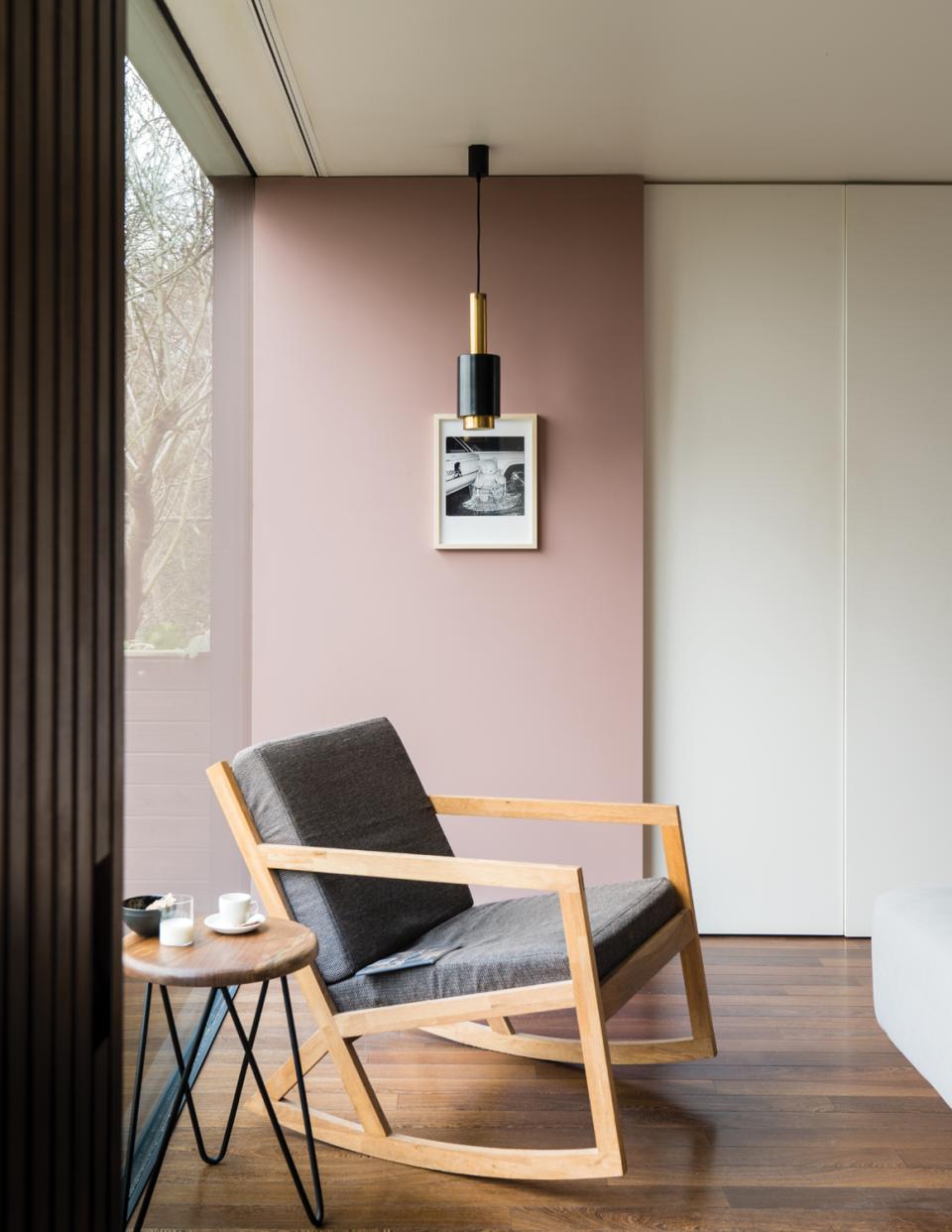 Sophisticated interior featuring Farrow & Ball's Sulking Room Pink paint, a rocking chair, and modern decor elements.