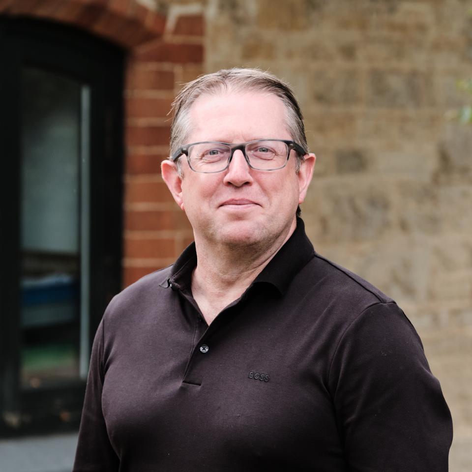 Andrew Bissell, partner at Ridge and Partners, discusses lighting design and neurodiversity against a rustic background.