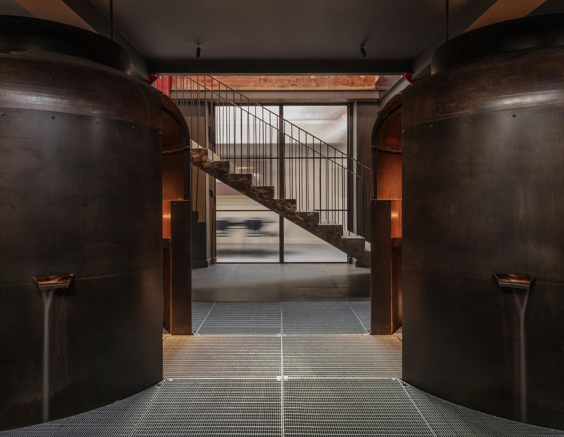 Modern showroom entrance of Holloway Li's Clerkenwell co-working space, featuring industrial design and a unique staircase.