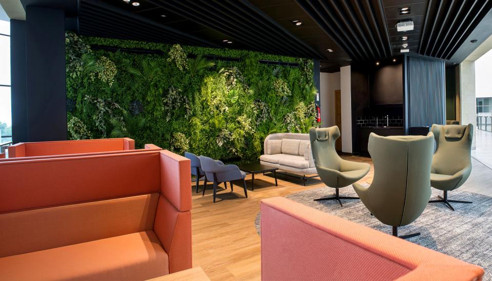 Modern lounge area at Alderley Park featuring vibrant green wall, stylish furniture, and a welcoming atmosphere for life science innovation.