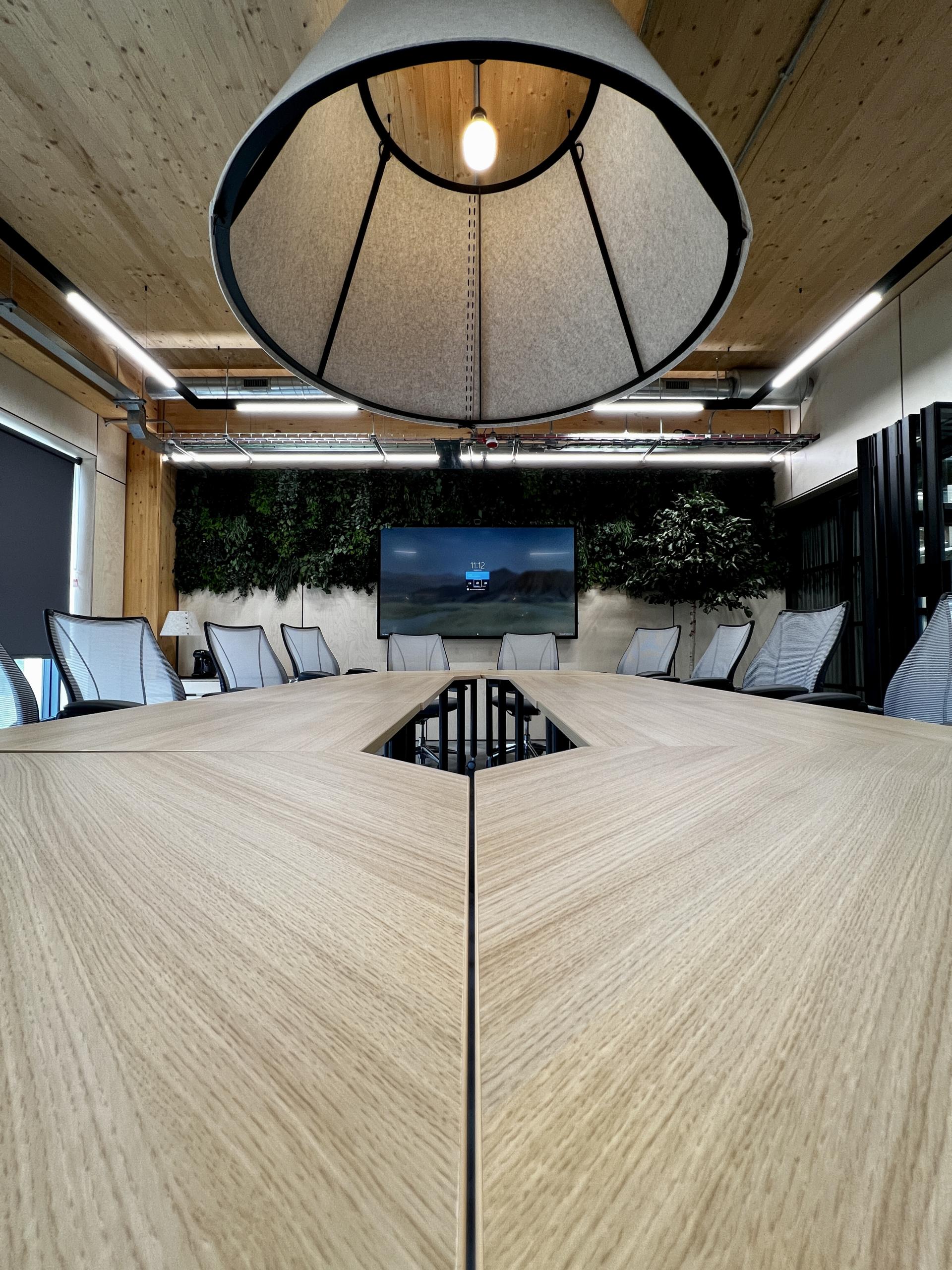 Modern meeting room featuring a sustainable wooden table and contemporary design elements, highlighting Leeds' first net zero carbon workspace.
