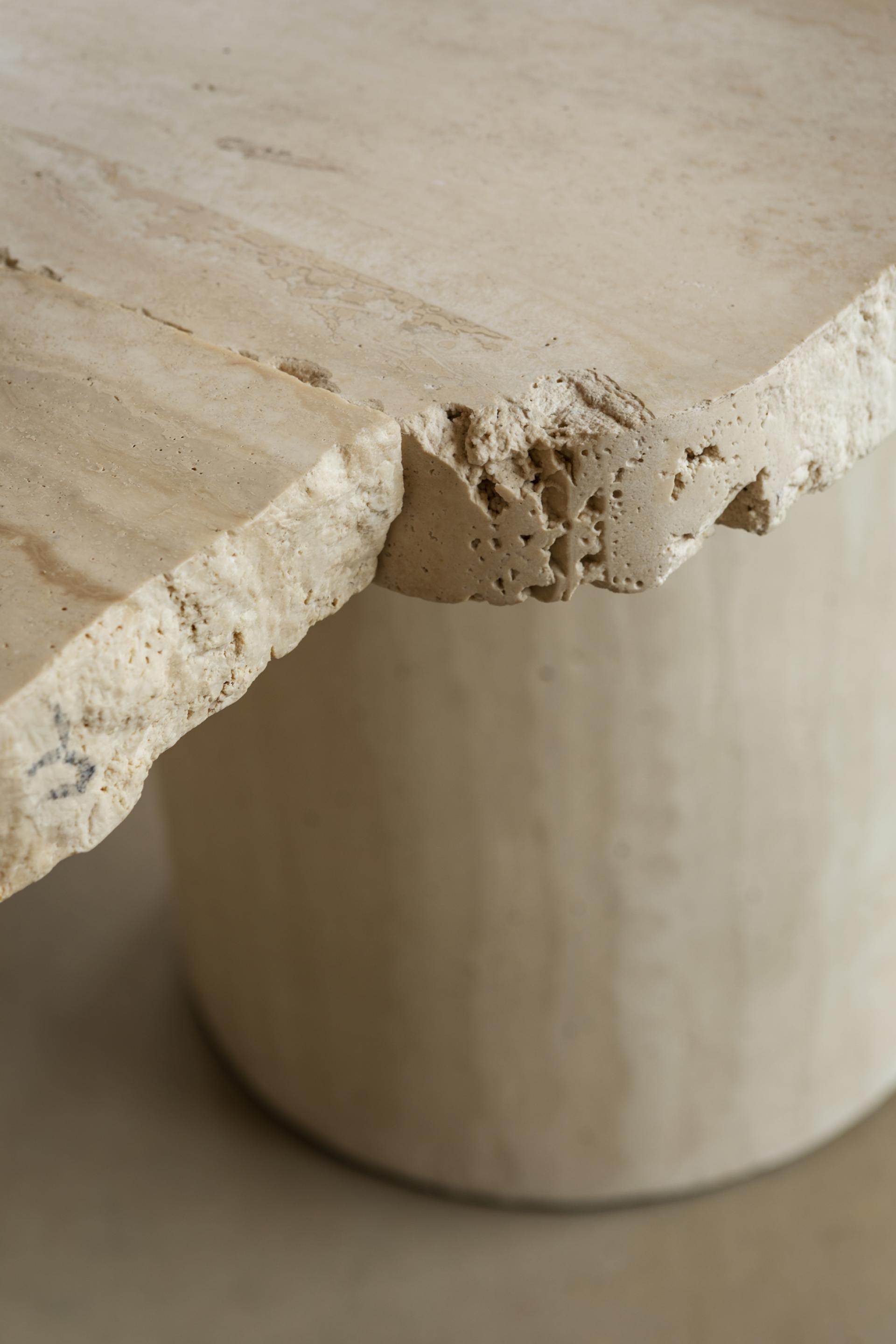 Textured stone table showcasing salvaged materials, reflecting circular design principles in sustainable store concept by Nina+Co for big.