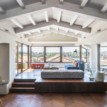 Luxurious artist's loft designed by Alvisi Kirimoto, featuring modern decor and stunning views of Rome's skyline.