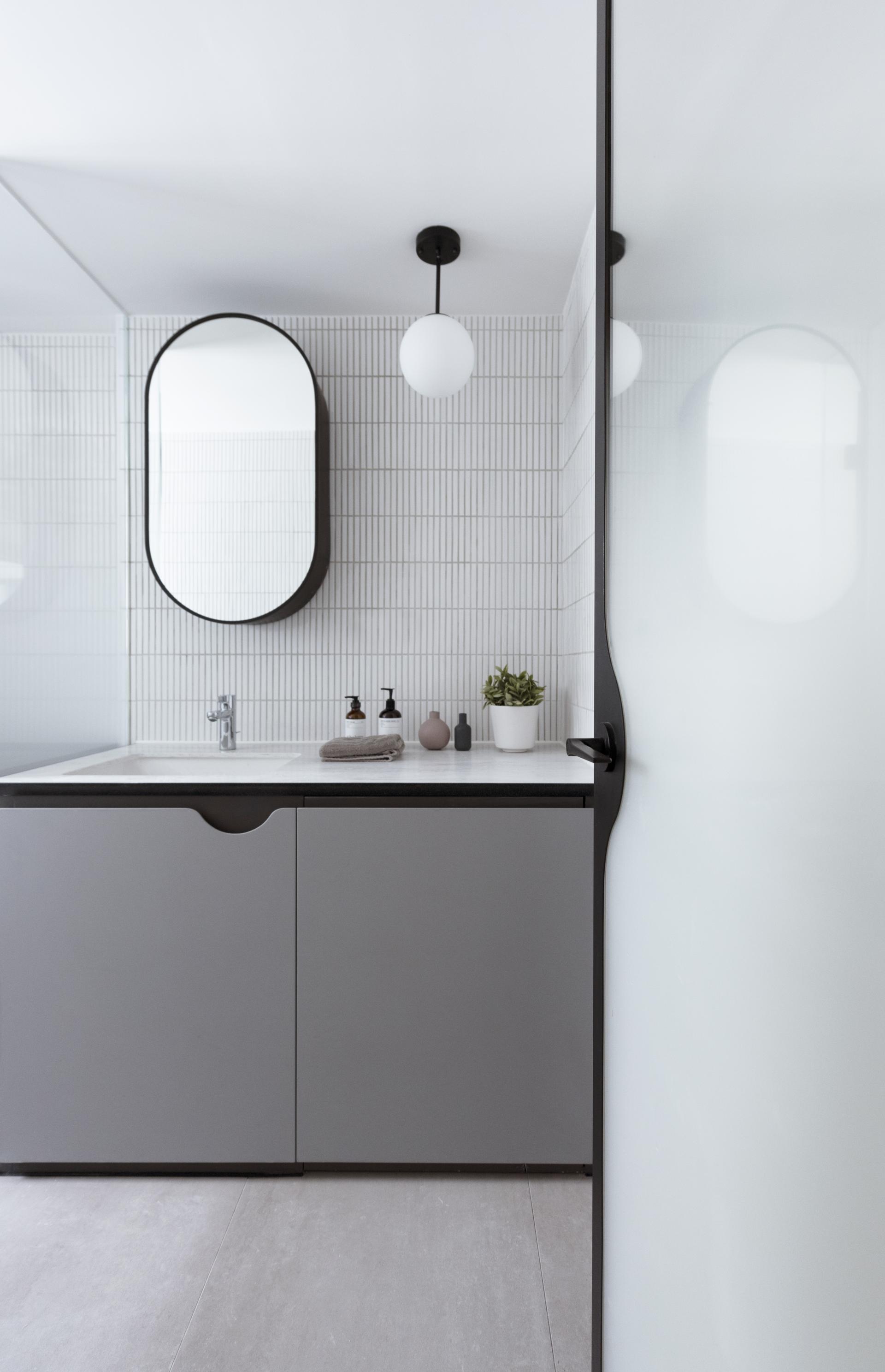 Contemporary bathroom featuring sleek cabinetry, modern lighting, and minimalist decor in a revitalized live-work space.