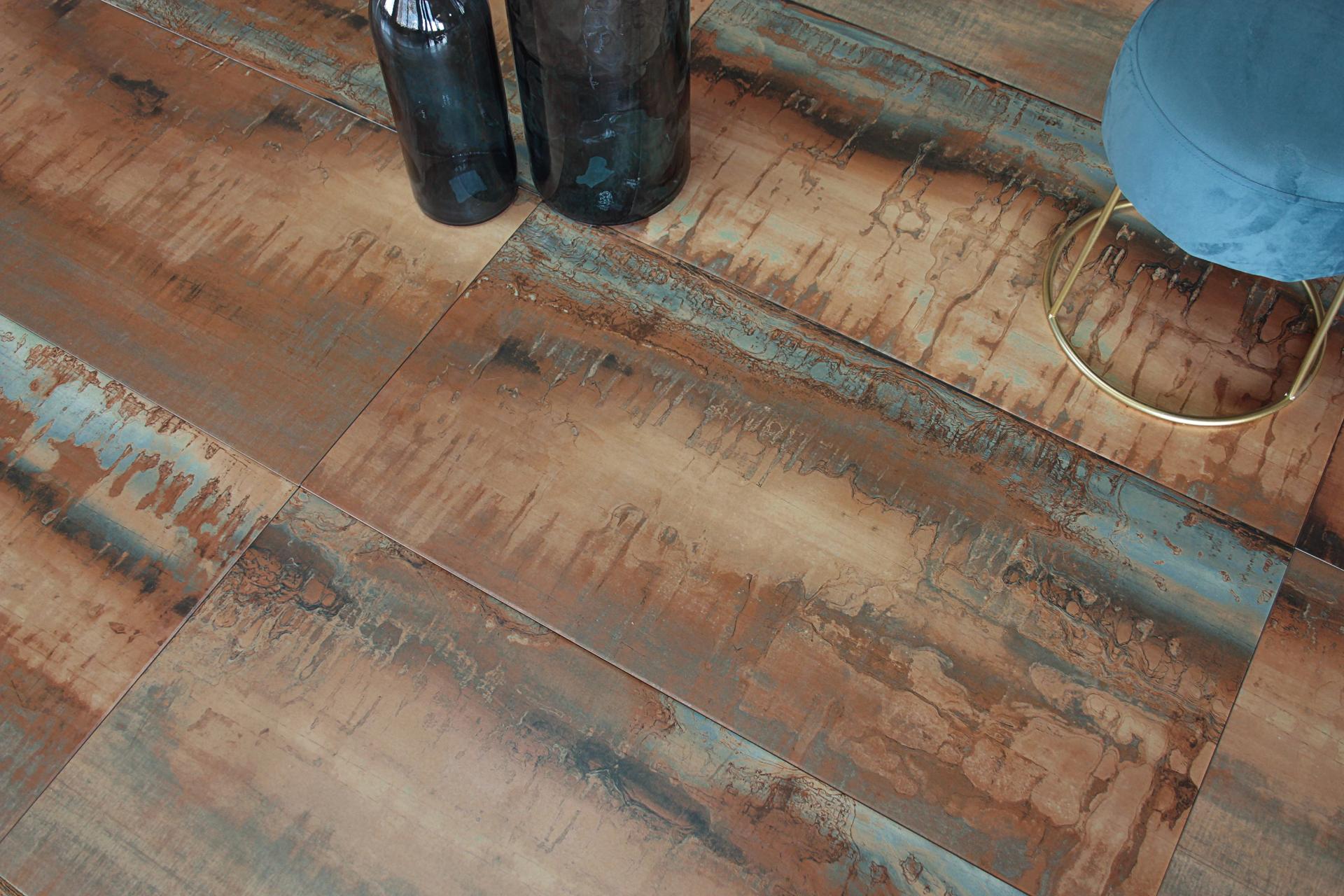 Rustic ceramic tile with earthy tones and blue accents, accompanied by decorative glass containers and a sleek stool.