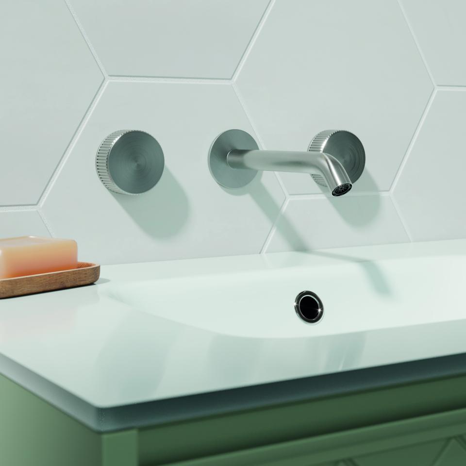Sleek wall-mounted faucet against a hexagonal tile backdrop, showcasing Crosswater's contemporary 3ONE6 brassware collection.