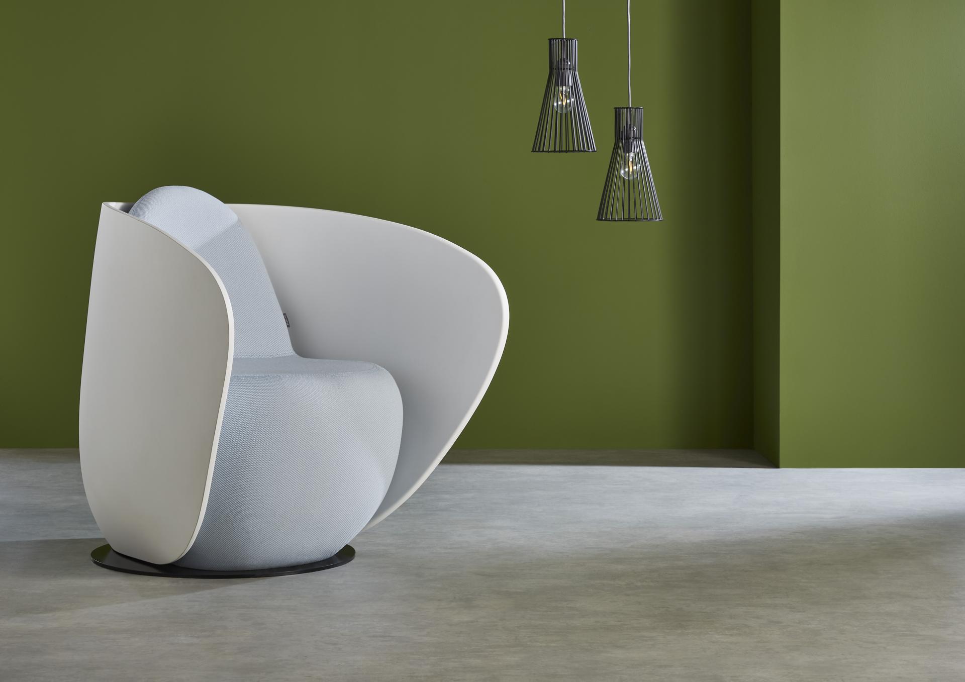 Rounded cocoon chair in light blue fabric against a calming green wall, ideal for serene workspace design.