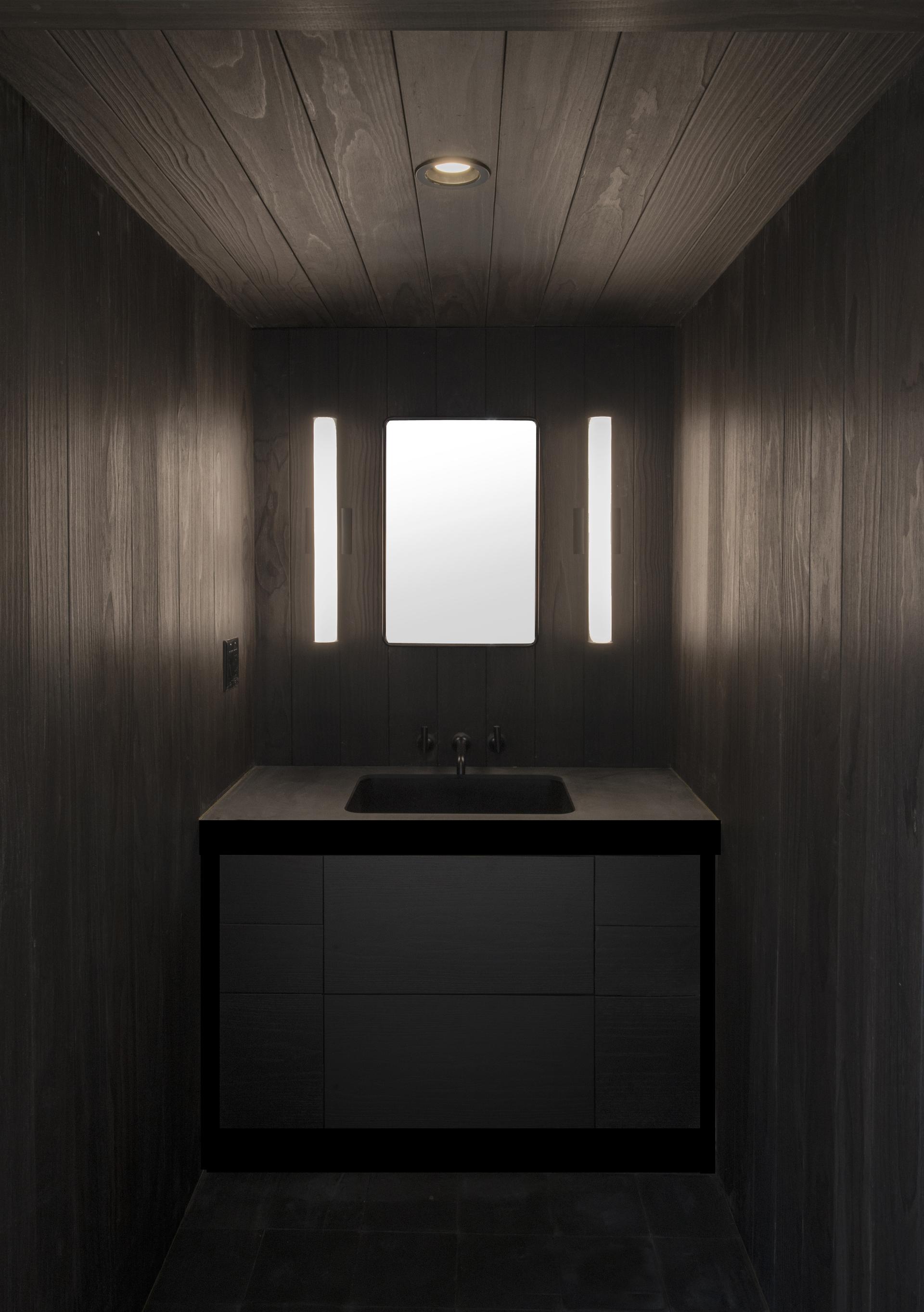 Modern bathroom design in Pioneer Square features a sleek black vanity and integrated lighting, showcasing space maximization.