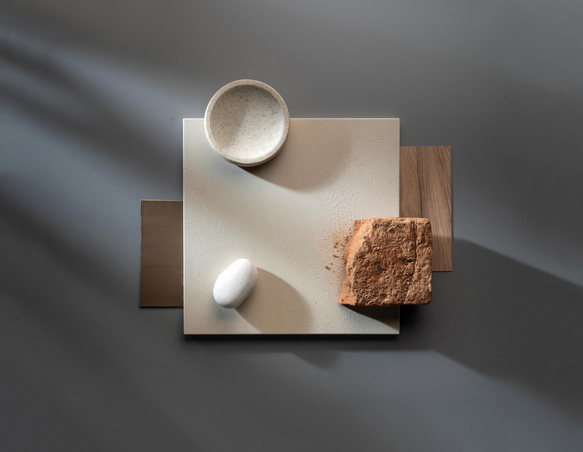 Dekton® Onirika and Kraftizen materials arranged artistically with natural elements, showcasing innovative surface design and textures.