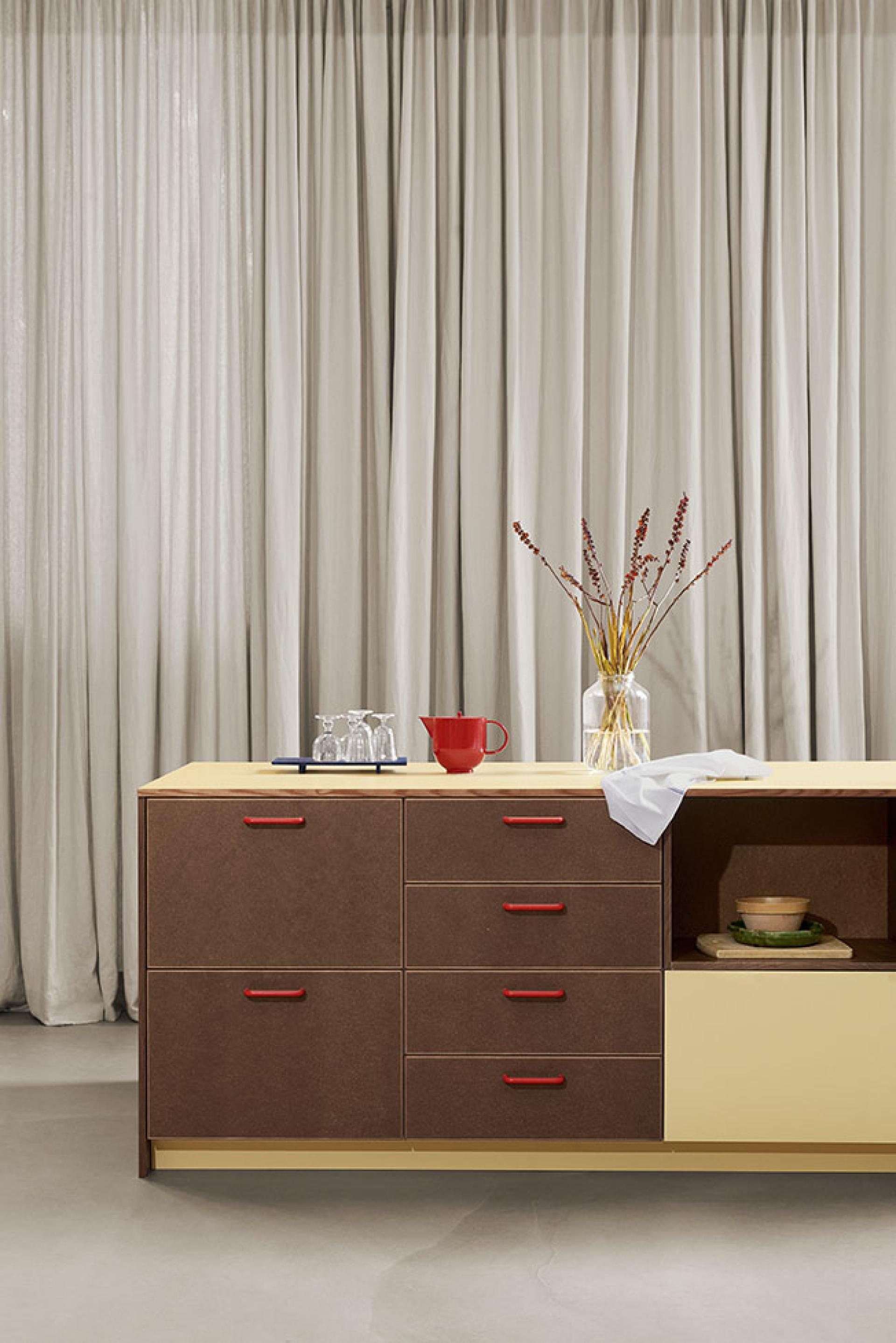 Modern kitchen featuring d line pull-handles, a decorative vase, and minimalist design elements in playful colors.