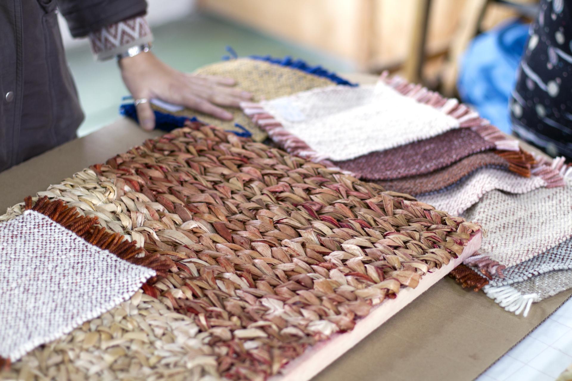 Hand touching colorful woven materials, showcasing the intricate textile design process behind Carolina Palombo’s Tutura chair.