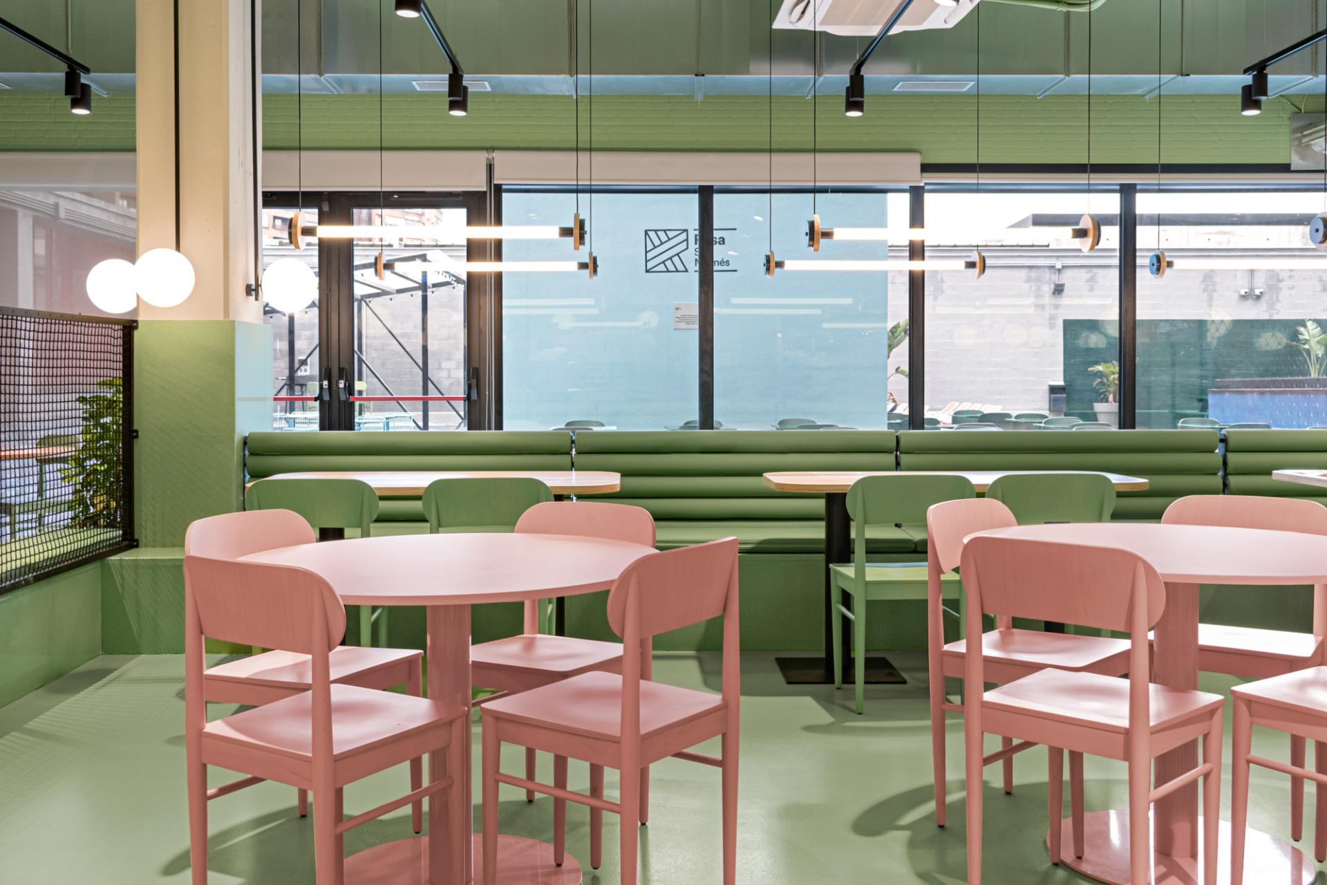 Brightly colored student residence dining area featuring pink and green furniture, designed in a Wes Anderson-inspired style.