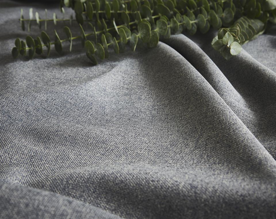 Textured fabric from ILIV's Tundra collection, showcasing a versatile grey color and natural eucalyptus leaves nearby.
