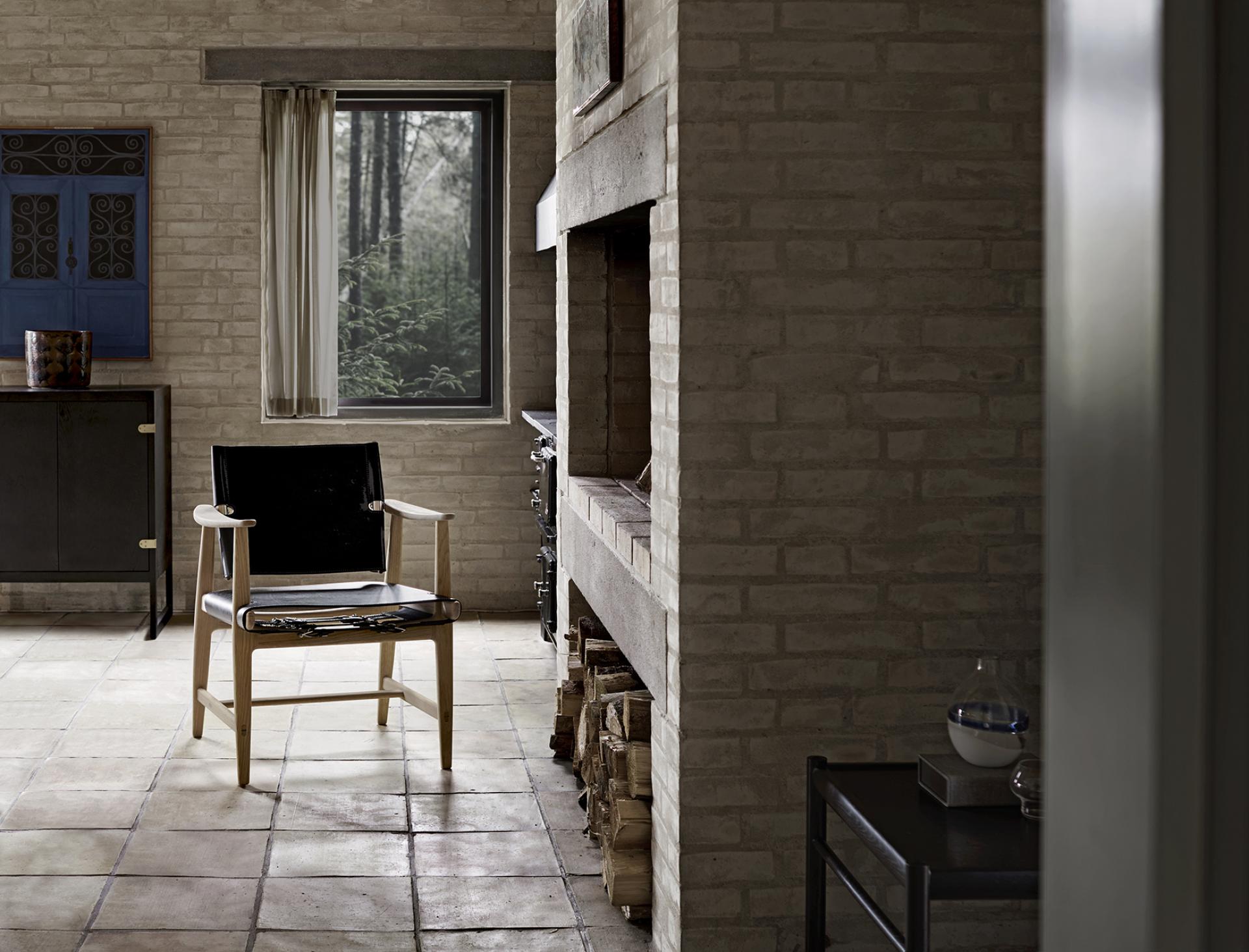 Elegant Børge Mogensen's Huntsman Chair showcased in a stylish interior with natural light and rustic decor.