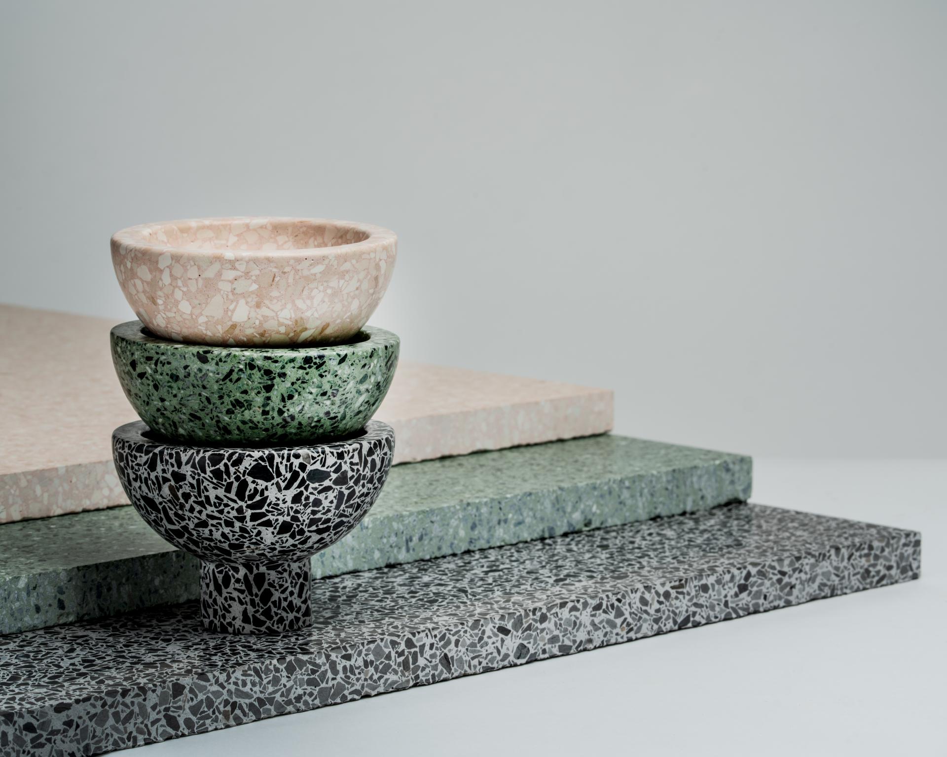 Colorful terrazzo bowls stacked atop textured terrazzo surfaces, showcasing Joyce Wang's Flint collection design at London Design Festival.