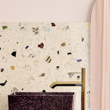 Stylish wood composite sink with gold faucet against a textured, colorful wall, highlighting sustainable washroom design.