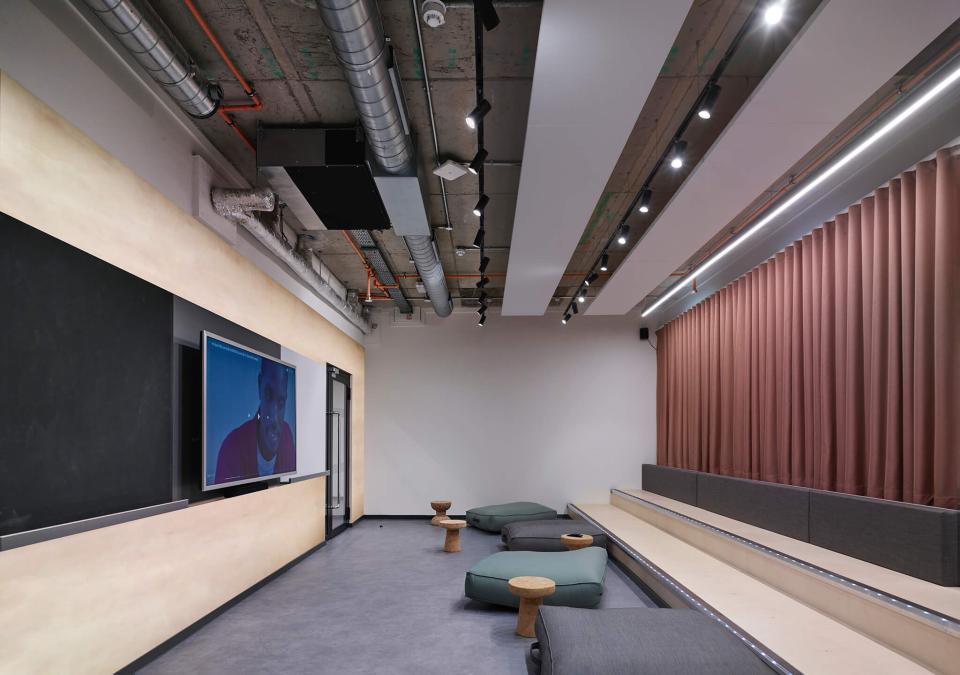 Modern student lounge at The Tannery in Leicester, featuring seating, a large screen, and stylish lighting.