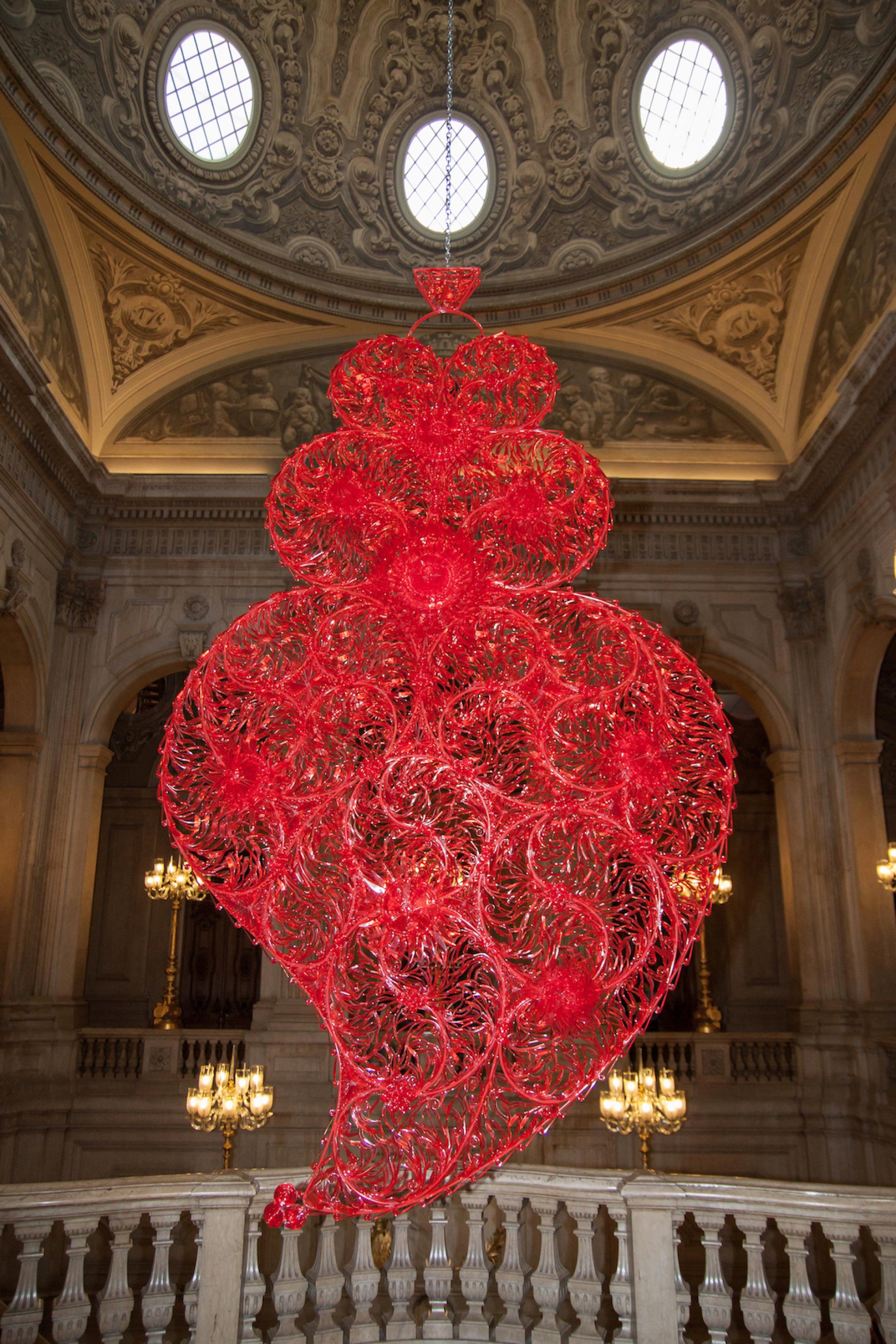 A vibrant red sculpture by Joana Vasconcelos suspended in an ornate historical setting at Yorkshire Sculpture Park.