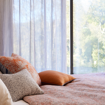 Stylish bedroom featuring Panaz's Meridian collection, showcasing textured fabrics and warm tones inspired by nature.