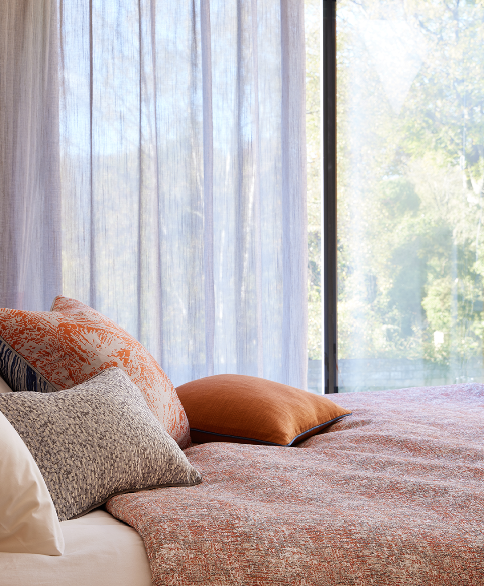 Stylish bedroom featuring Panaz's Meridian collection, showcasing textured fabrics and warm tones inspired by nature.