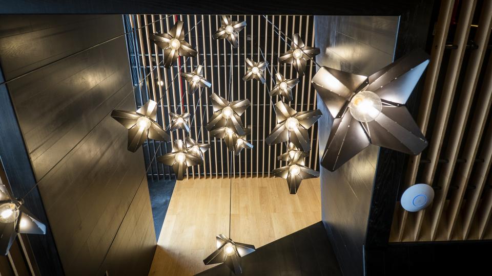 Stylish pendant lights shaped like stars hang from the ceiling, creating a modern atmosphere in the Brew92 coffee shop.