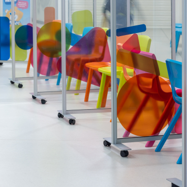 Colorful modern chairs and dividers in a children's hospital waiting area designed for comfort and calmness.