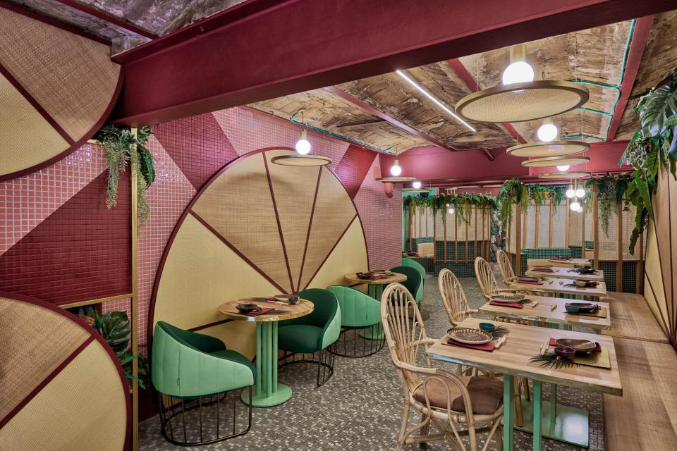 Colorful interior of Kaikaya, Valencia's first tropical sushi restaurant, featuring lush decor and unique seating arrangements.