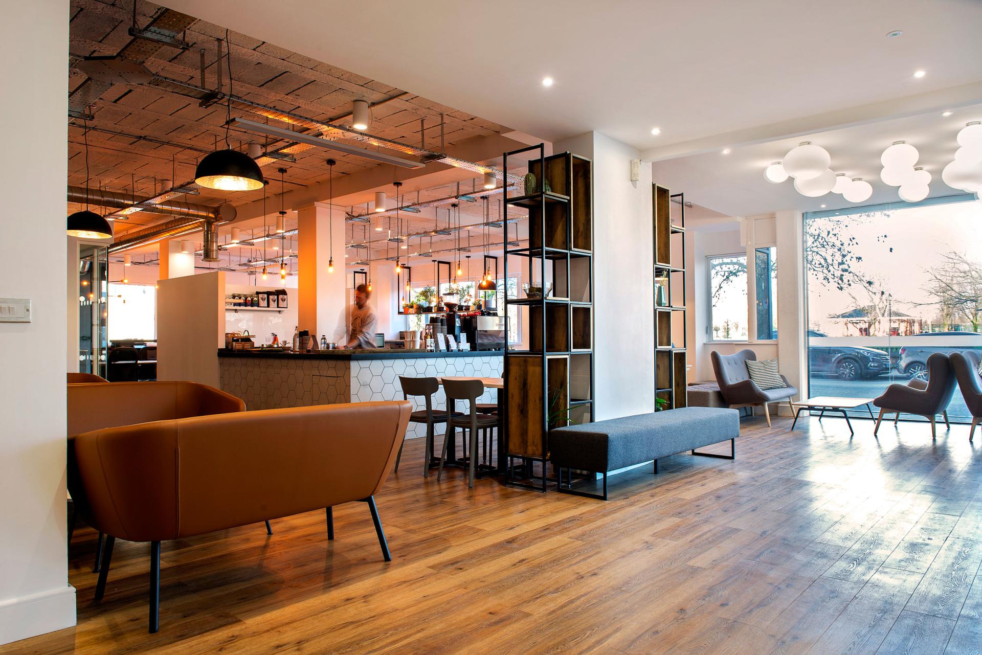 Modern interior design featuring a welcoming café space with stylish furniture and bright natural light.