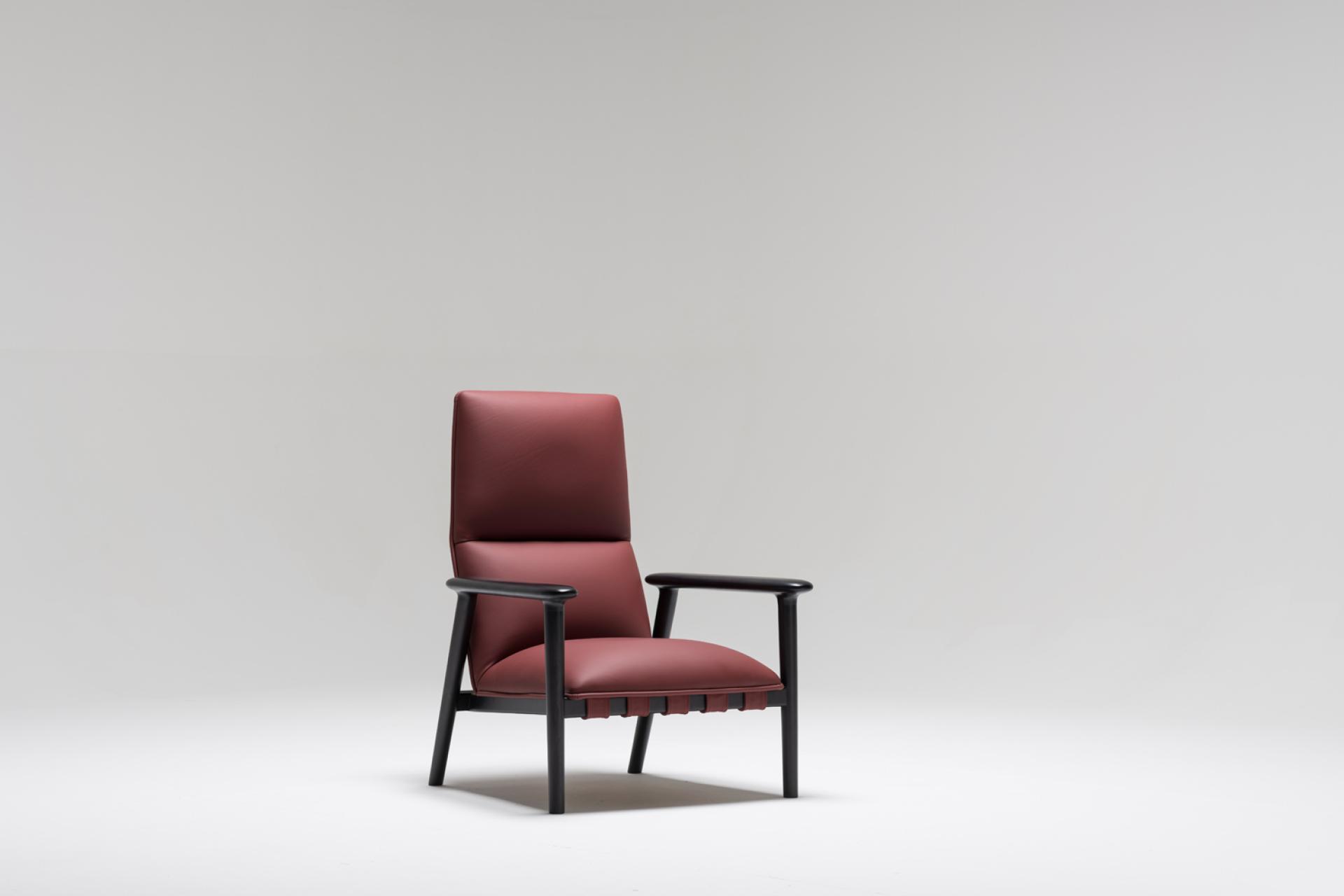 Modern burgundy armchair with black wooden frame, showcasing contemporary design and elegant materials by designer David Fox.