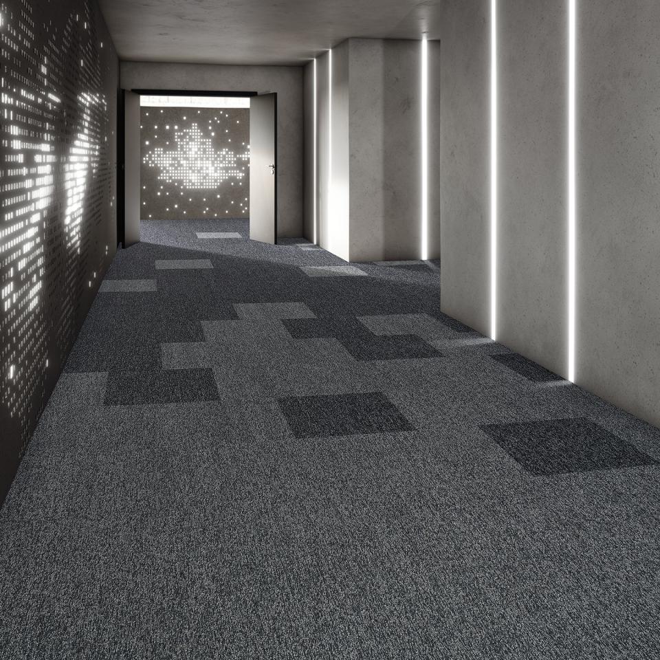 Modern corridor featuring modulyss Delight collection of shimmering carpet tiles in mixed metallic patterns under soft lighting.