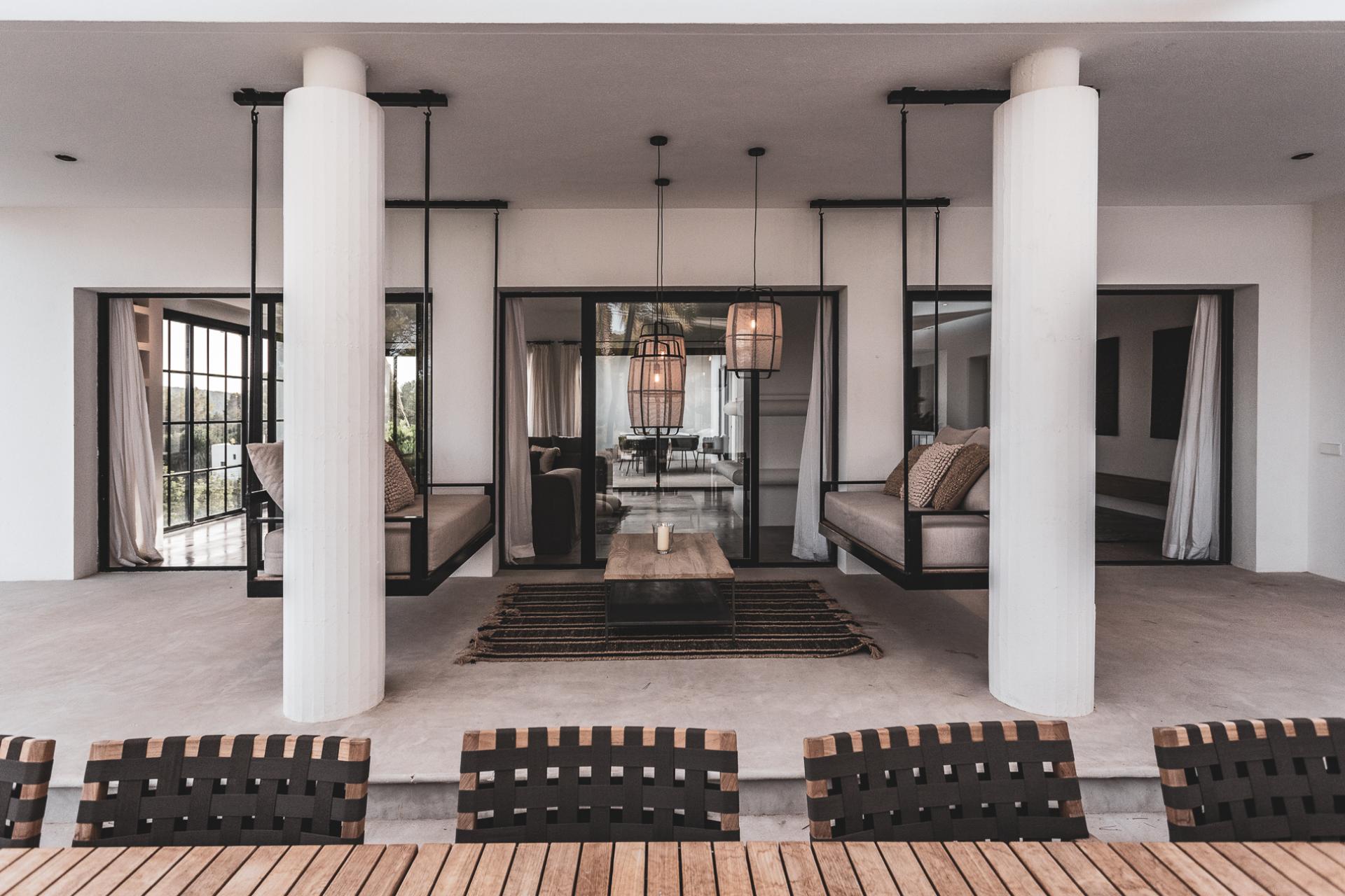 Stylish interior featuring hanging seating, minimalist design, and a warm ambiance, showcasing Theresa Obermoser's interior design expertise.