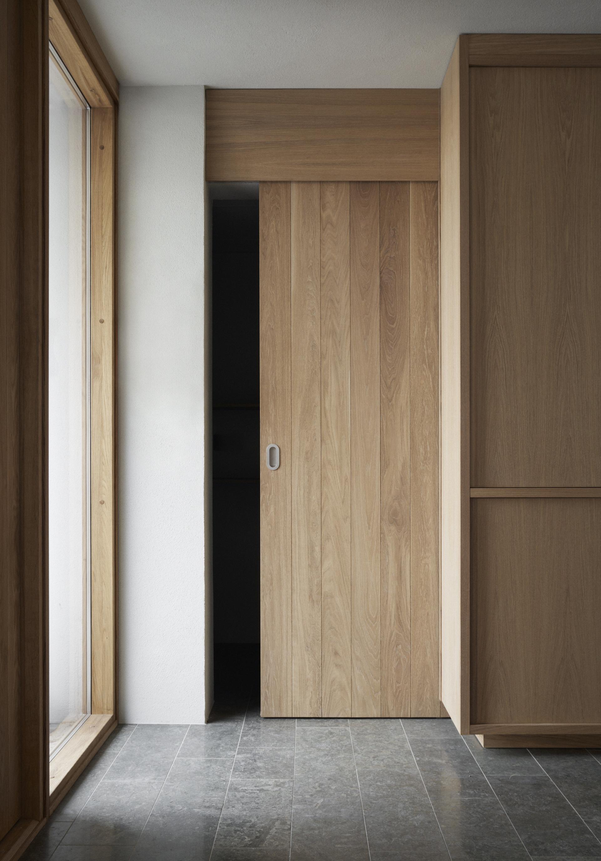 Wooden sliding door and minimalist interior design in a stylish hallway, showcasing Scandinavian aesthetics at Vyn, Sweden.