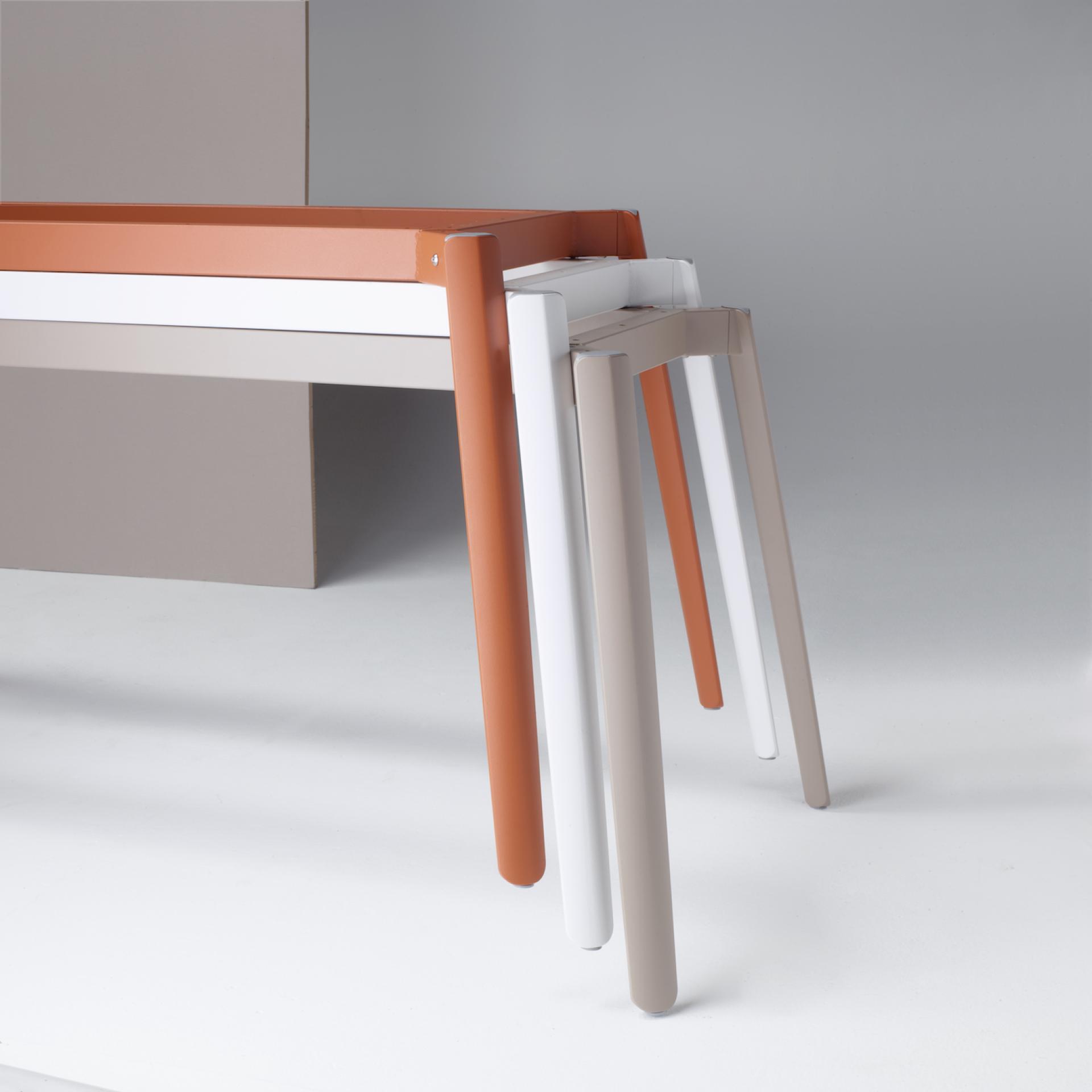 Cuttlefish bone-inspired tables featuring sleek, modern designs with multi-colored legs in orange, white, and beige tones.