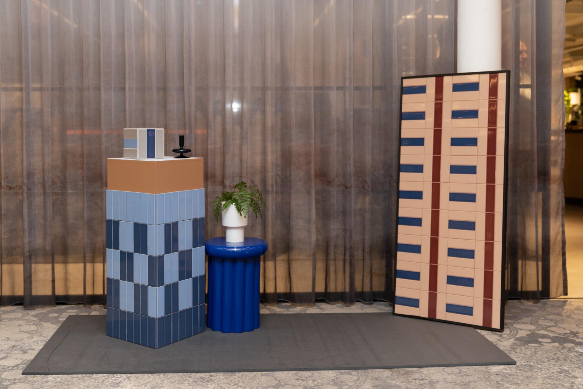 Colorful tile displays and furniture pieces from the Färgblock collection, showcasing playful designs by Tekla Severin and Ramona Macchi.