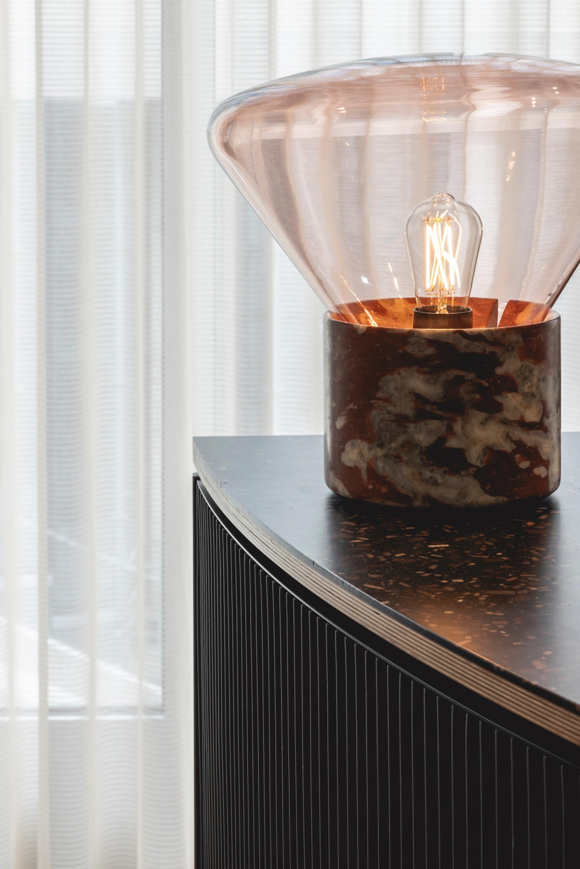 Art Deco-inspired lamp with a glass shade and marble base, illuminating a stylish workspace designed by Ekho Studio.