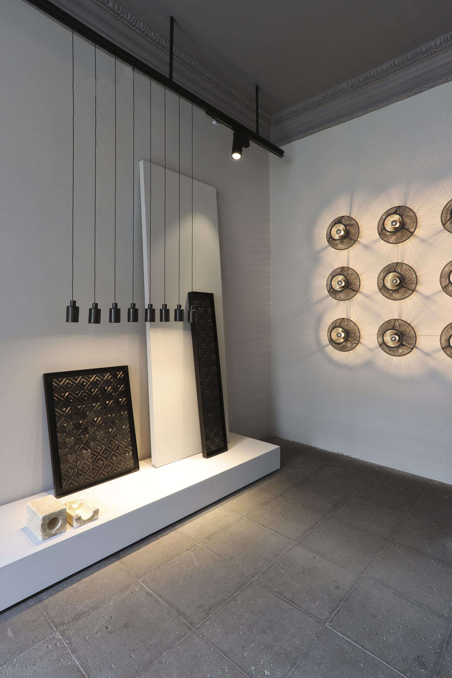 Showroom interior featuring local Mexican materials, showcasing artistic wall panels and modern lighting fixtures in Mexico City.