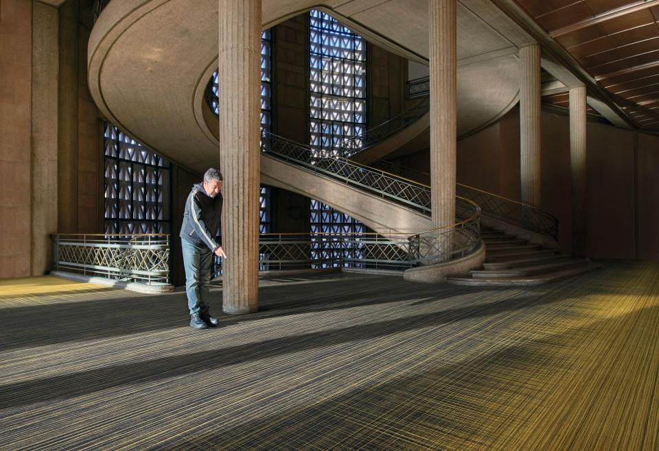 A designer inspects the new Flotex By Starck flooring collection in a modern architectural space.