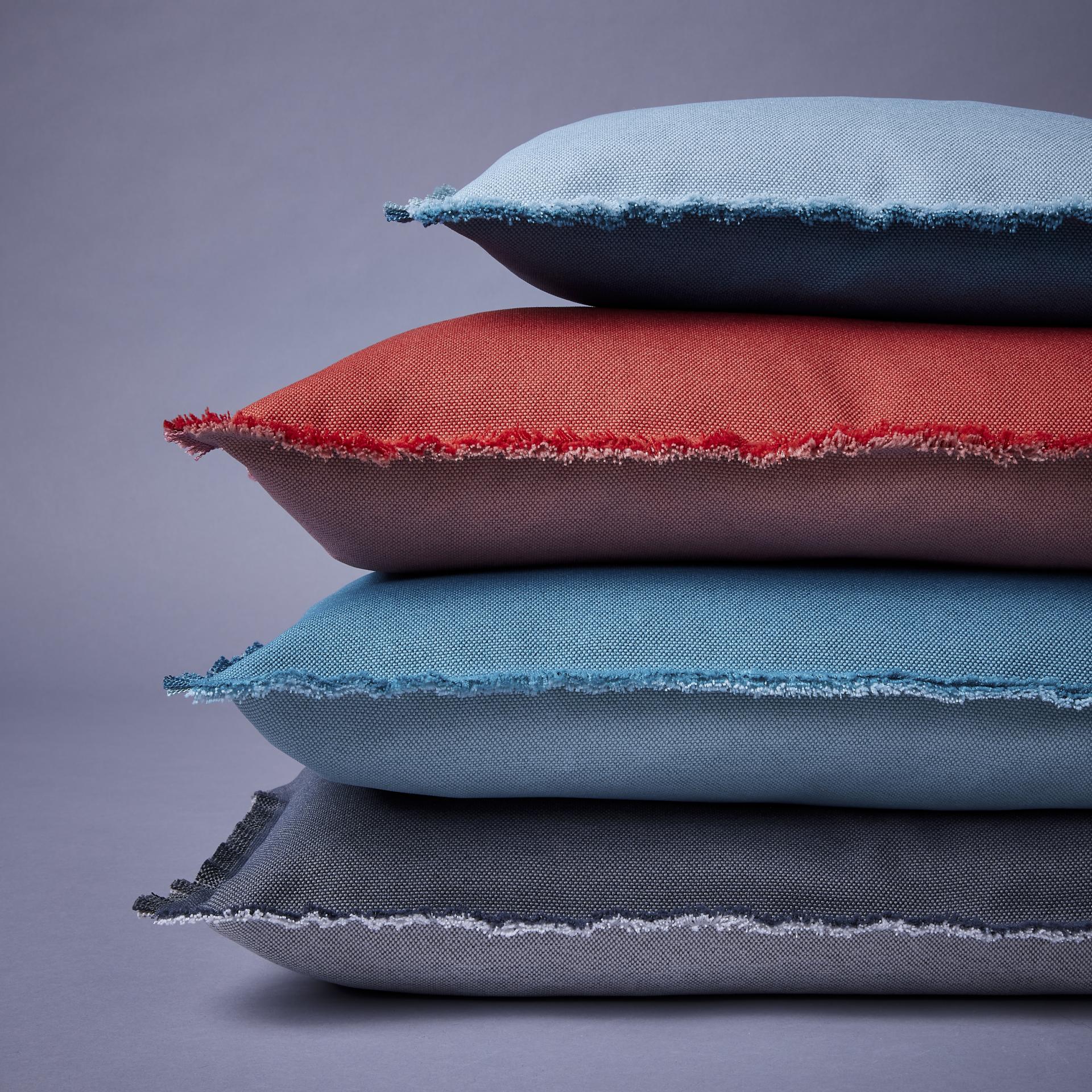 Colorful, textured cushions made from marine plastic waste, showcasing Camira's commitment to sustainability and reducing ocean pollution.