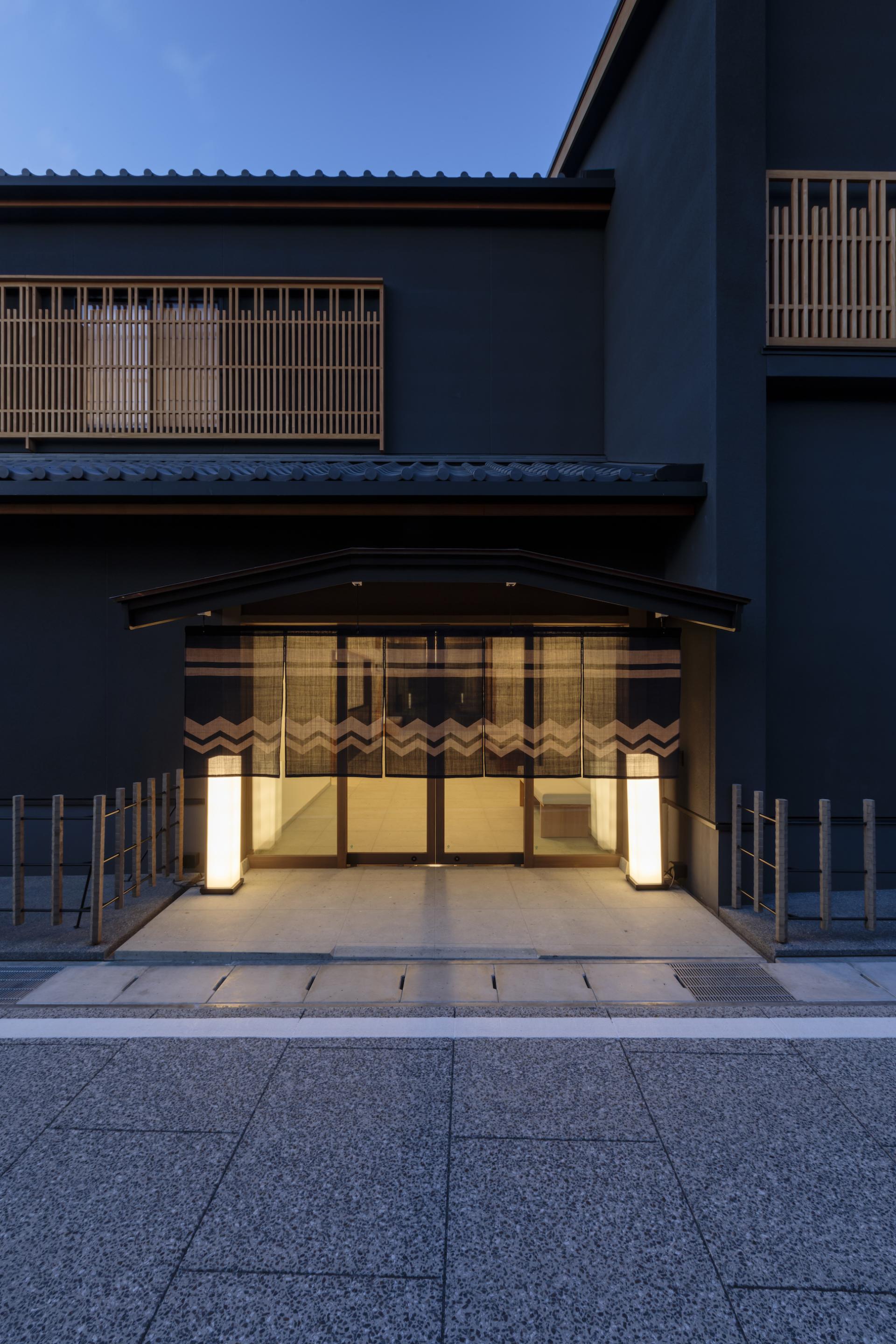 Modern ryokan entrance of Azumi Setoda, featuring traditional design elements and welcoming lights on a tranquil island.